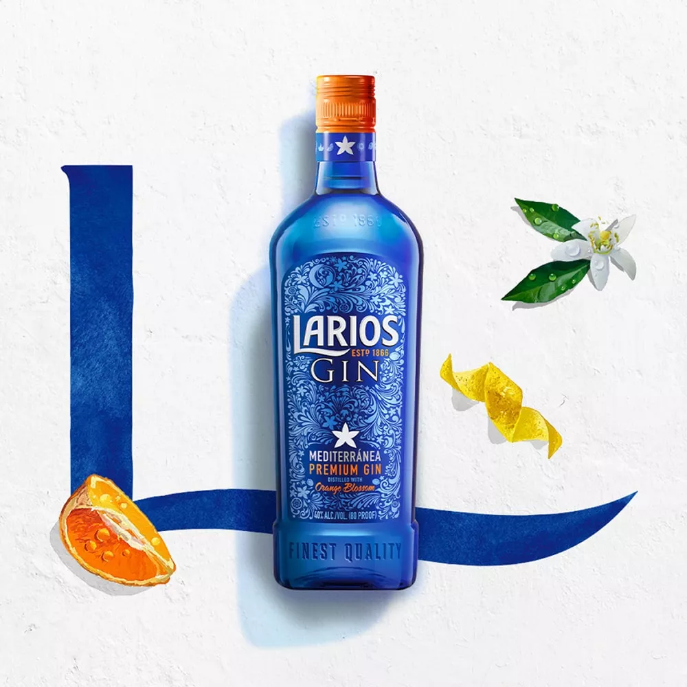 A bottle of Larios dry gin beside a fresh cut of orange