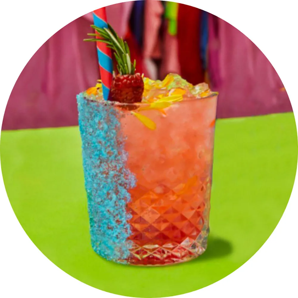 A glass of Gin Rose Lemonade colorfully garnished with blue sugar